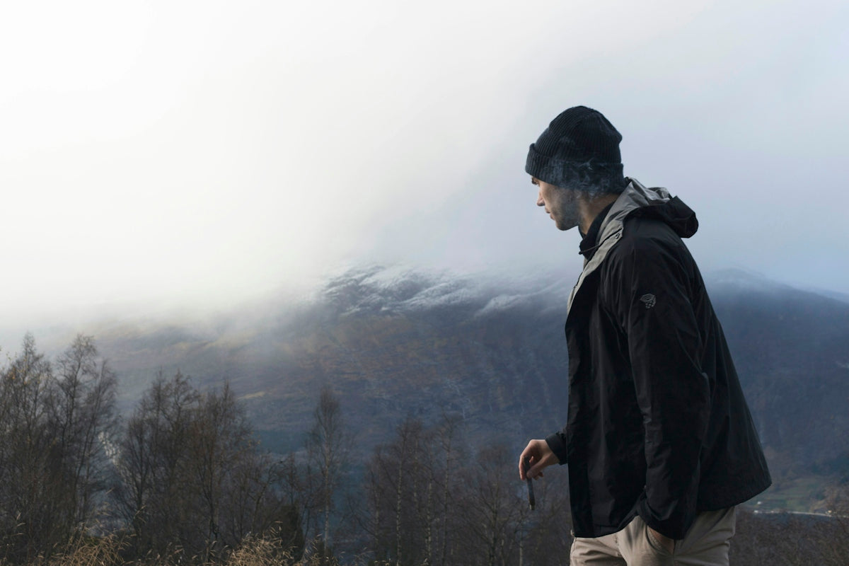man wearing black jacket looking at mountain