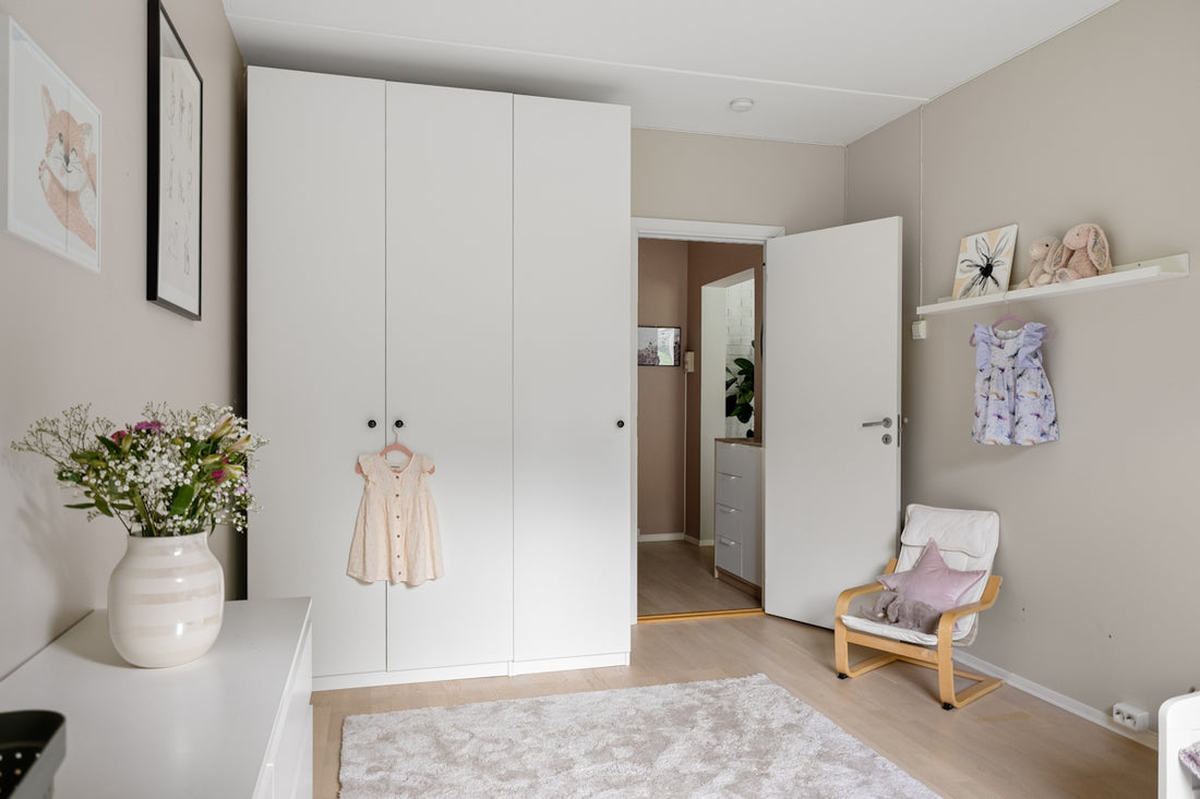 A bedroom with a white closet and a white chair