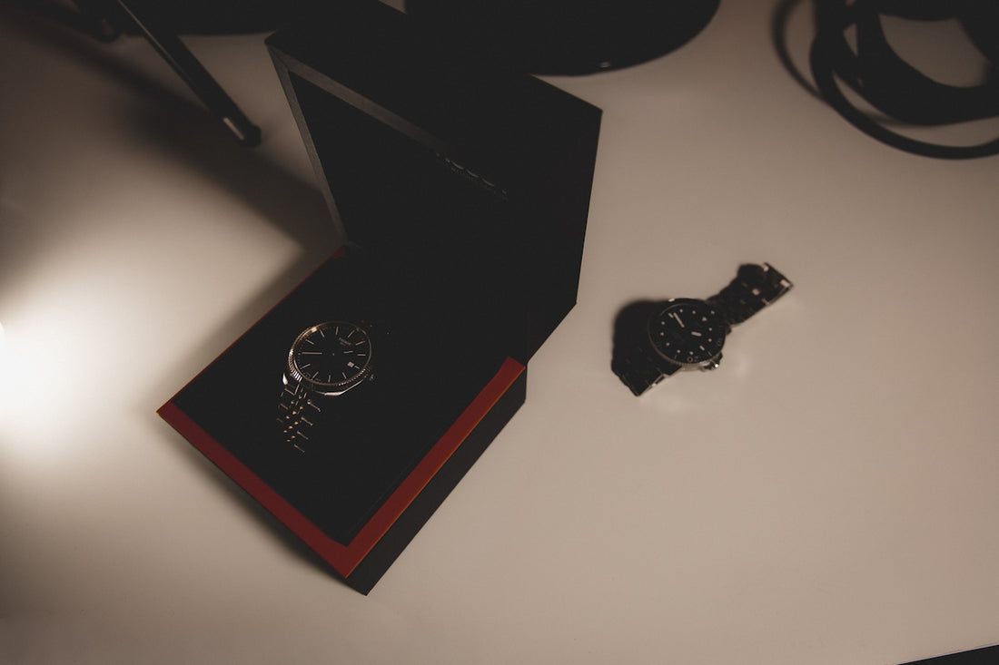 A wristwatch in a black box on a white surface