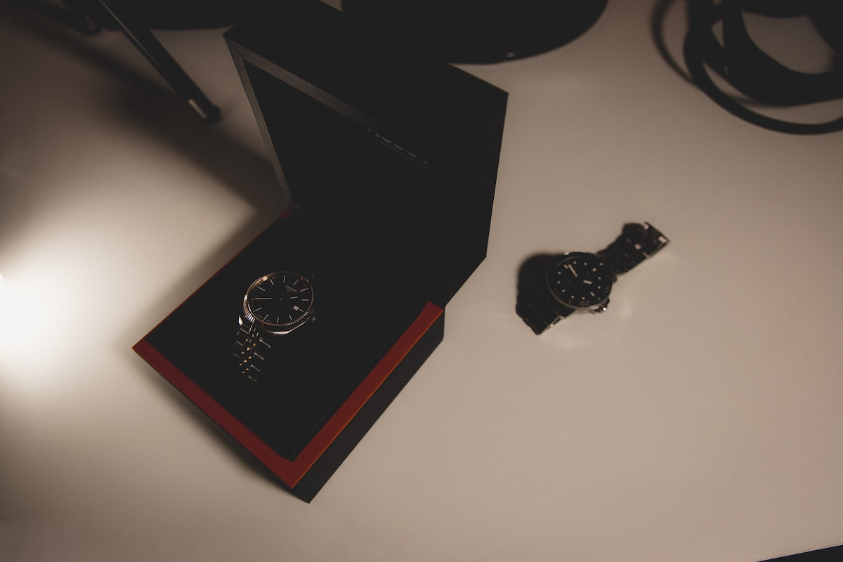 A wristwatch in a black box on a white surface