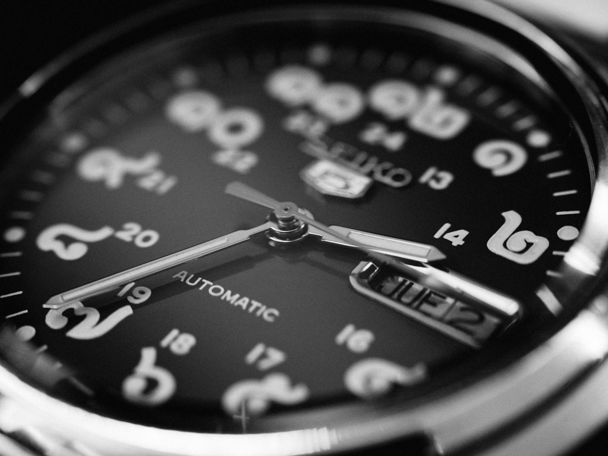 Black and white automatic watch face showing time and date
